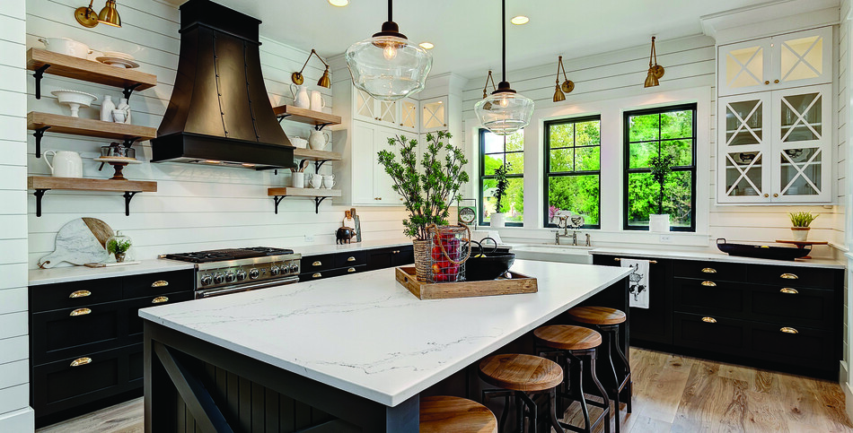 A kitchen island and countertop of white Statuario Nuvo quartz threaded with the dark grays and soft browns of a classic marble stone.