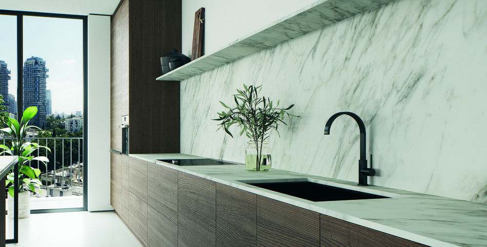 Modern kitchen with horizontal dark wood lower cabinets, a white Archetta porcelain marble-look countertop and backsplash, and black fixtures.