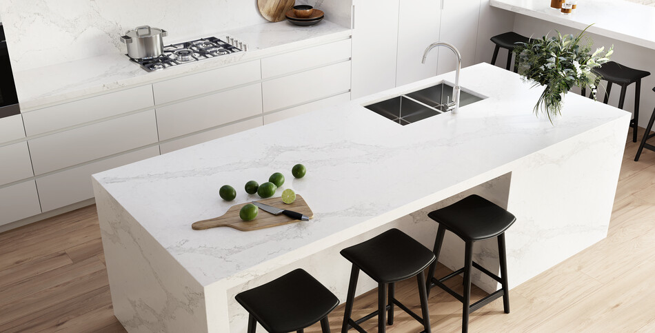 A kitchen island in Calacatta Nuvo quartz of creamy white with cascading gray streaks.