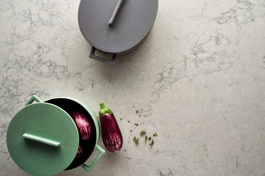 Light grey veined kitchen counter with pots and eggplants 