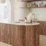 Modern kitchen with wooden cabinetry, island, steaming pot, open shelves, and cityscape view.